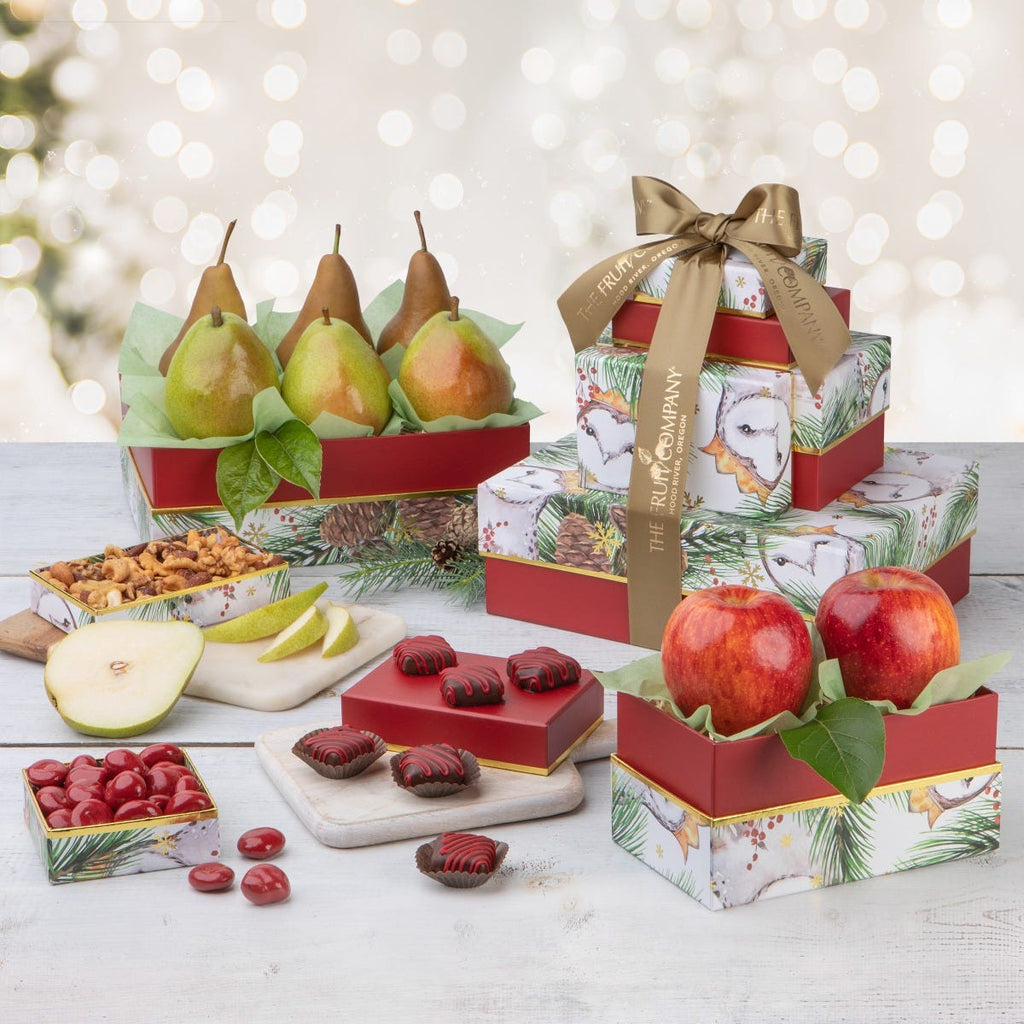 5 red with gold trim and pine-cone themed boxes filled with fruit and treats and gold ribbon