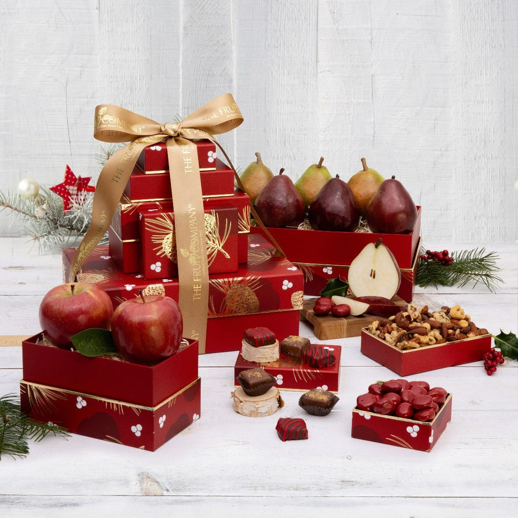 5 red with gold trim and pine-cone themed boxes filled with fruit and treats and gold ribbon