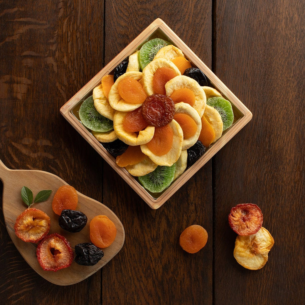square tray of 5 types of dried fruits pistachios and almonds arranged in a small flower pattern 
